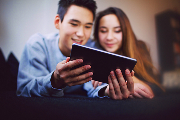 un couple rigolent à propos d'un contenu sur leur tablette